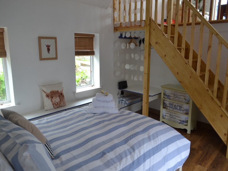 cosy bedroom with stairs up to mezzanine lounge